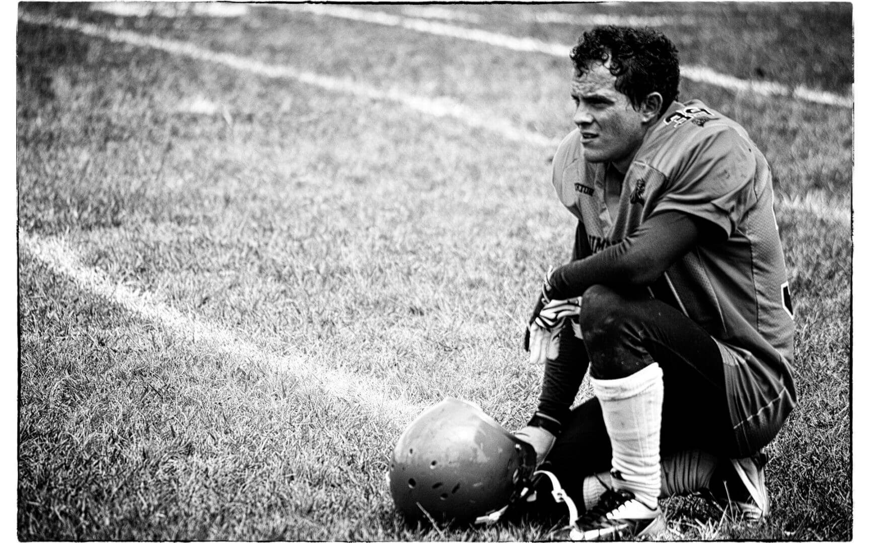 Football player resting on the field.