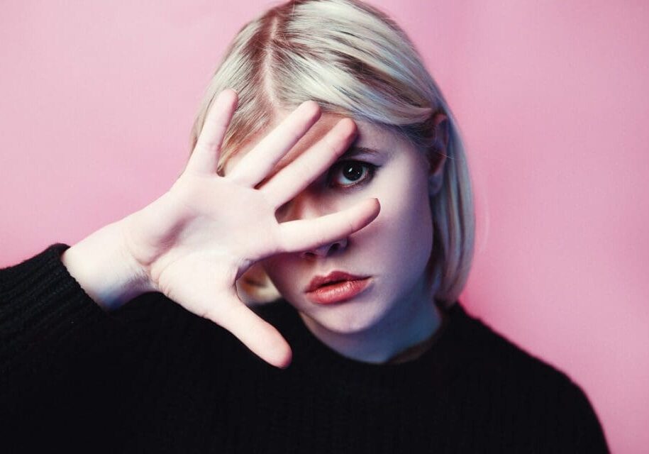 Person posing with hand covering one eye.